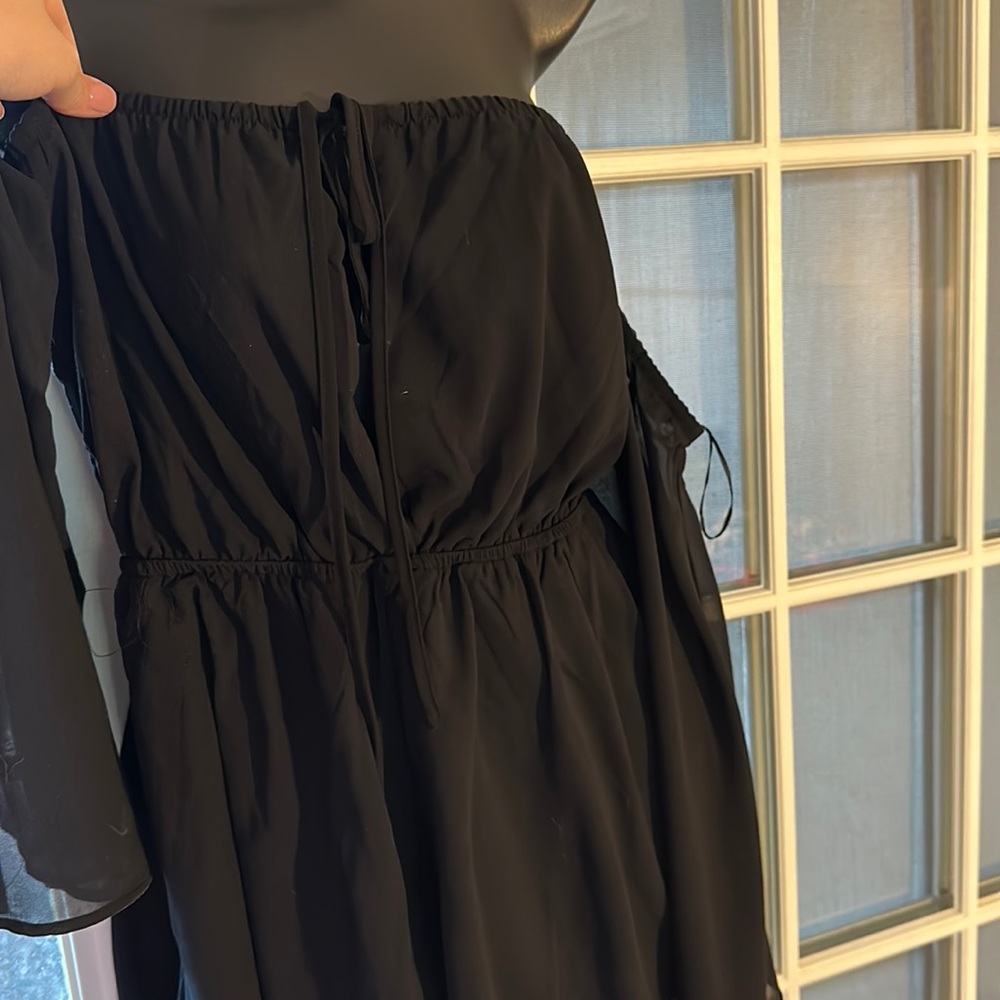 Black “sleeveless” romper with pull up side sleeves.